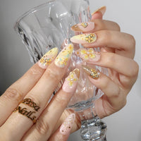 Thumbnail for Hand with floral nail design holding a clear glass against a neutral background
