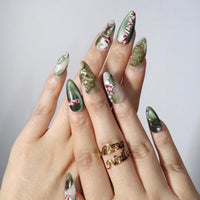 Thumbnail for Hand with green and gold nail art on a plain background